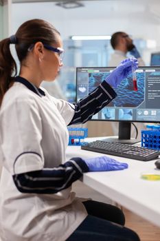 Medical researcher analyzing blood in test tube for vaccine development wearing protection glasses . Healthcare scientist working in modern laboratory using modern technology.