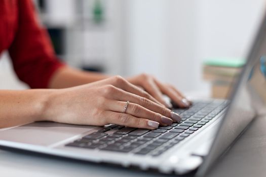 Close up of businesswoman manager hands fingers typing documents on laptop keypad. Detail shot of etrepreneur pressing on keyboard with fingers. Laptop receiving imput from