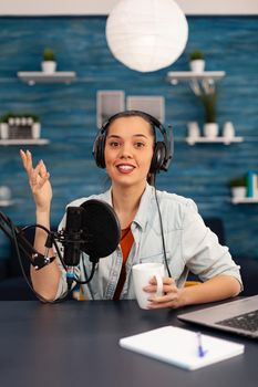 Content creator looking at camera while talking into microphone during beauty podcast. Creative online show On-air production internet broadcast host streaming live video, recording digital social
