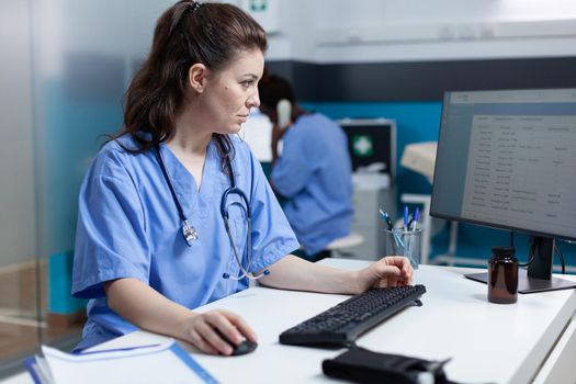 Pharmacist specialist nurse analyzing medical examination using computer in hospital office during clinical appointment. Asisstance checking pharmaceutical medication working at healthcare treatment