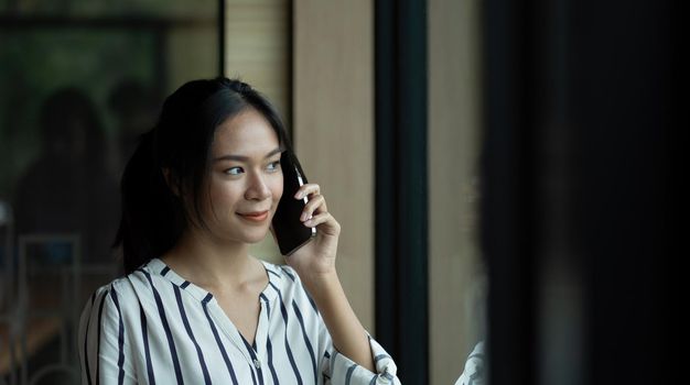 Close up Young Asian Woman Talking to Someone on her Mobile Phone.