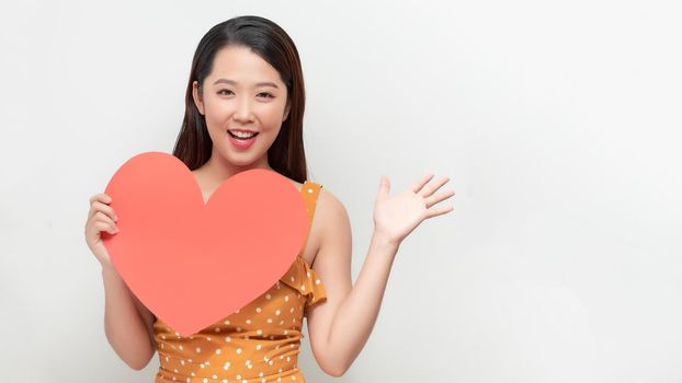 Woman holding big red heart on white background