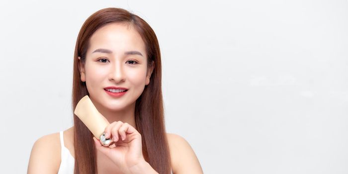 Young asian woman showing skincare products