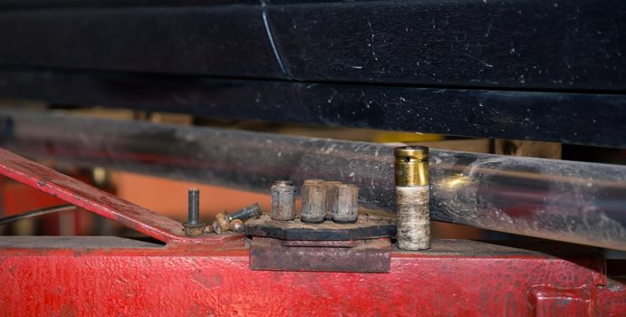 Metal heads of a pneumatic socket wrench on the lift support. In the garage, a man changes parts on a vehicle. Small business concept, car repair and maintenance service. UHD 4K.