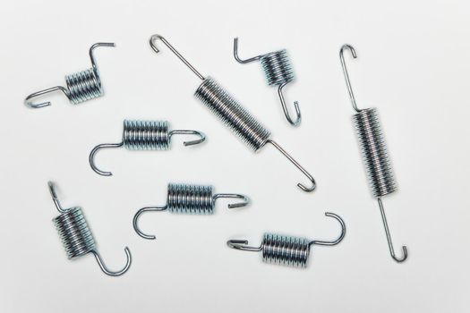 Repair kit for brakes, several metal springs of various lengths. Set of spare parts for car brake repair. Details on white background, copy space available. UHD 4K.