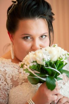 Portrait of a fat bride with a wedding bouquet.