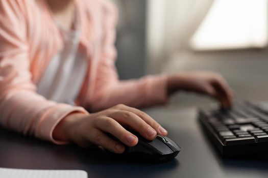 Close up of student hand typing on computer keyboard technology for online internet connection class. Smart little girl using digital devices for schoolwork and education knowledge