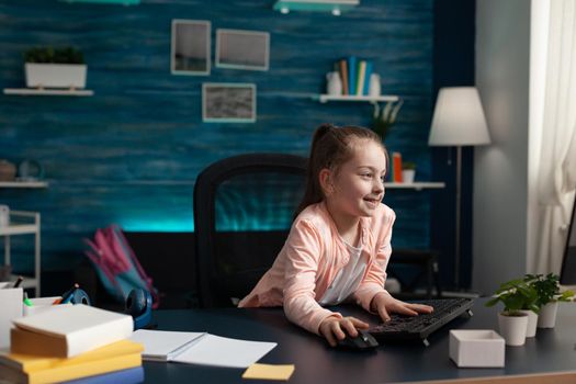 Smart little pupil looking at computer monitor screen at home for online class lesson. Caucasian student paying attention to lecture studying for elementary exam work and knowledge