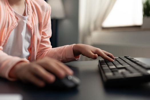 Close up of student hand typing on computer keyboard technology for online internet connection class. Smart little girl using digital devices for schoolwork and education knowledge