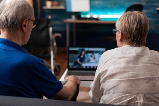 Worried grandparents on video call chat with family sick in hospital for healthcare. Elder couple using online conference internet to check up healing treatment progress for little girl