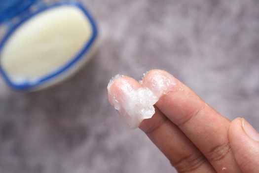 Close up of man hand using petroleum jelly .