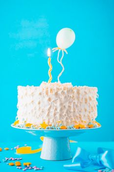 decorative cake illuminated candle blue backdrop. High resolution photo