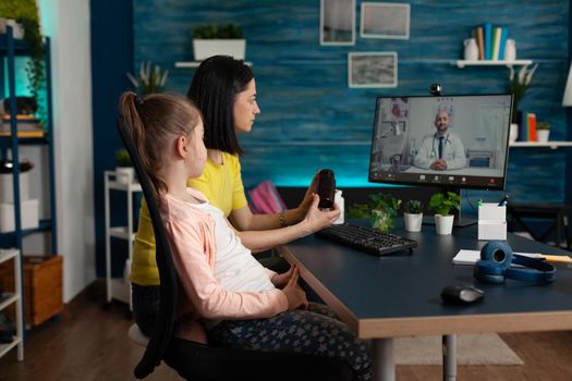 Mother asking doctor about pills on telemedicine video call internet conference at home for unwell little girl. Family of two using online virtual communication with healthcare specialist