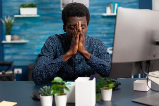 Sick african american guy stressing about deadline project having big headache. Exhausted black man worrying about business while working from home in cozy flat. Tired overwhelmed person