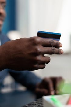Online transaction consumer buying with credit card, introducing payment data. African american man making purchase on internet website using digital technology and spending money