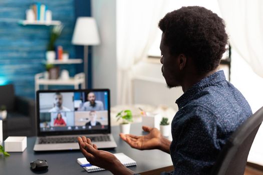 Black man remote employee working from home taking online office call with partners and colleagues. Computer user from desk on video internet conference via webcam conference