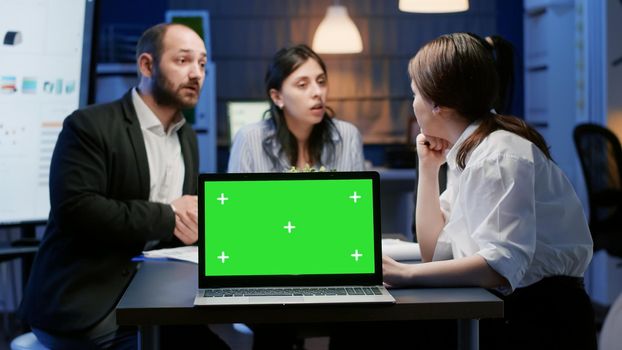 Mock up green screen chroma key with isolated display standing on table conference in meeting room. Diverse multi ethnic businesspeople discussing management strategy planning company presentation