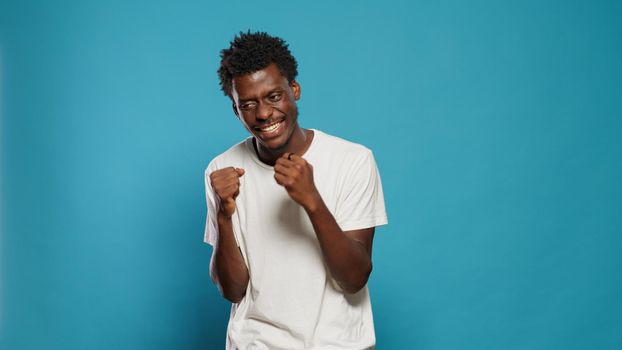 Angry man showing emotions and clenching fists in studio. Portrait of frustrated person feeling nervous and displeased while preparing for fight. Negative adult with aggressive expression