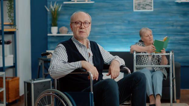 POV of disabled old man using video call communication in nursing home facility. Aged person with chronic disease sitting in wheelchair while talking on online remote conference with family