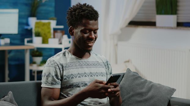 Person using smartphone with touch screen for text messages and remote communication. Man holding gadget and texting, talking to friends as free time activity after online work.