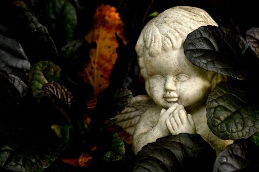 sweet angel figure on a grave in autumn