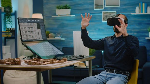 Architect using vr glasses for building model design in architectural office. Man engineer working with headset and virtual reality to analyze construction layout and development.