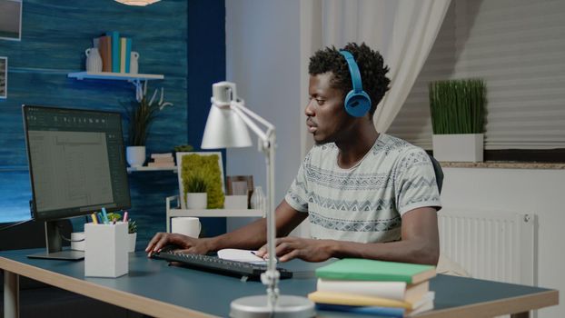 Black man working as engineer with architectural software on computer. Architect of african ethnicity looking at blueprint sketch to design building model layout for construction plan.