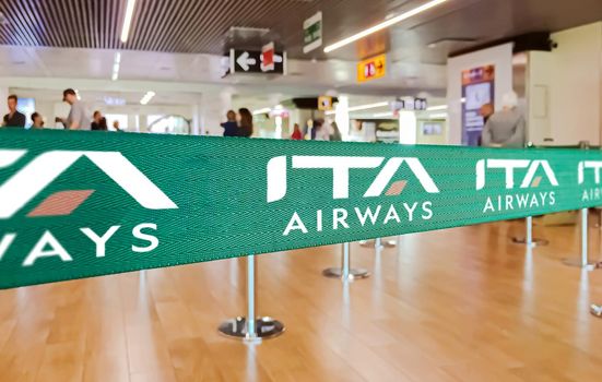 Fiumicino, Italy, Oct 2021: green ribbon barrier with the ITA airways logo inside the Leonardo da Vinci airport in Rome, Italy. ITA Airways is the new Italian flag carrier from 15 October 2021