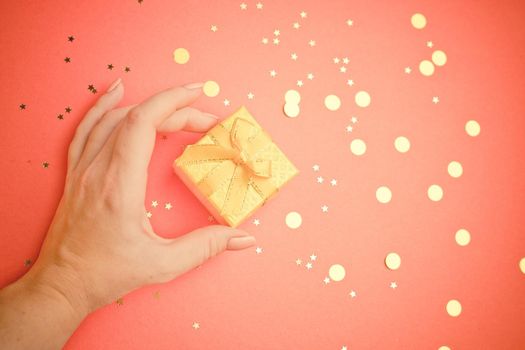 A New Year 's gift in a woman 's hand . A Christmas present. Copy space. An article about choosing a gift. Holiday