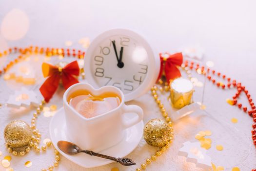 A clock in a New Year's layout on a white background. New Year's gifts. An article about the New Year and Christmas. It's almost 12 o'clock