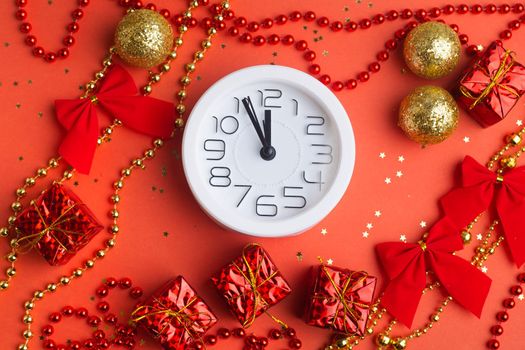 A clock in a New Year's layout on a red background. New Year's gifts. An article about the New Year and Christmas. It's almost 12 o'clock