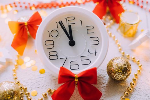 A clock in a New Year's layout on a white background. New Year's gifts. An article about the New Year and Christmas. It's almost 12 o'clock