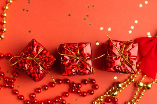 Red Christmas gifts and Christmas trees on a red background. An article about the New year and Christmas. The choice of gifts. A red gift . New Year's background