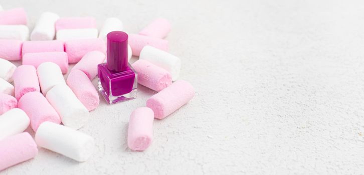 Nail polish and marshmallows . Marshmallow on a white background. An article about nail polishes. Cosmetology. Decorative cosmetics. Copy Space