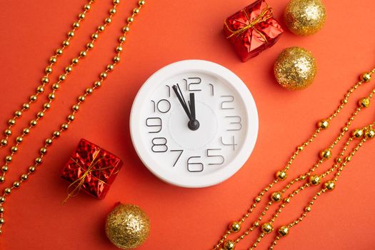 A clock in a New Year's layout on a red background. New Year's gifts. An article about the New Year and Christmas. It's almost 12 o'clock