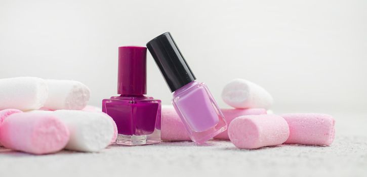 Nail polish and marshmallows . Marshmallow on a white background. An article about nail polishes. Cosmetology. Decorative cosmetics. Copy Space