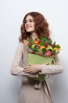 cheerful woman smile posing fresh fruits bouquet emotions light background. High quality photo