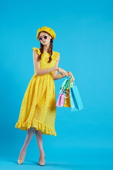 cheerful woman in a yellow hat Shopaholic fashion style studio model. High quality photo