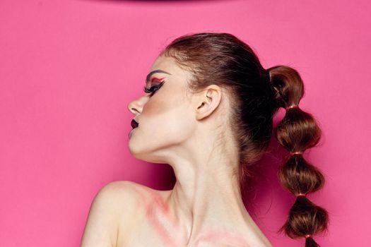 pretty woman naked shoulders cosmetics bright makeup pink background. High quality photo