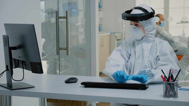 Stomatology assistant working at desk for patient teethcare using modern computer and oral radiography. Nurse and dentist doing dental consultation during coronavirus pandemic