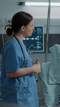 Nurse checking oximeter on sick patient in hospital ward and african american doctor consulting treatment progress. Elder man with IV drip bag and nasal oxygen tube healing disease