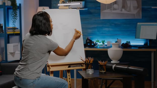 Young african american artist creating vase design on canvas at art studio. Black woman with artistic imagination drawing masterpiece for successful professional occupation and hobby