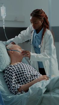 Multi ethnic medical staff running to help ill patient with oxygen tube and heavy breathing problems. African american doctor preparing from reanimation at intensive care unit