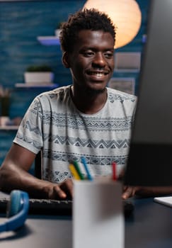 Portrait of african american young employee working remote from home at communication project using computer. Entrepreneur man browsing online management information. Business project