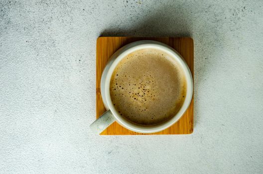 Cup of coffe with milk on white concrete table