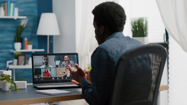 African american manager on online internet conference chat with his coworkers, remote working from home, using teleconference web communication with webcam. Black guy distance technology talking