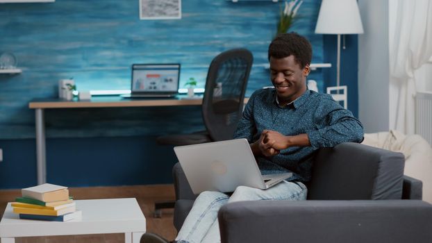 Overburdened overworking exhausted african american man suffering from sleep deprivation, falling asleep with laptop in front of him. Portrait of tired freelancer working from home