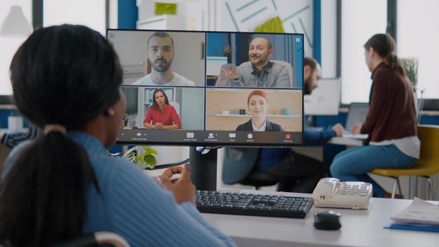 Disabled black manager discussing with remote team using videocall talking online during virtual meeting sitting in wheelchair in strat up business office. Diverse coworkers planning financial project