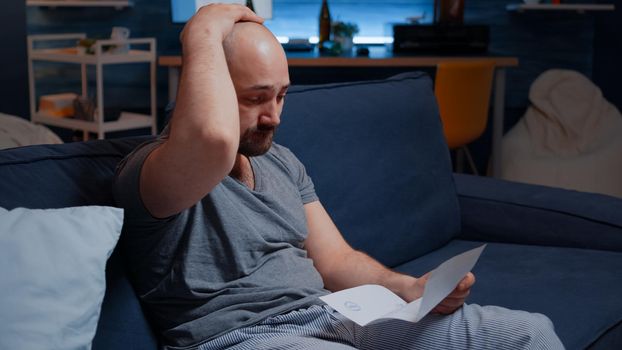 Worried anxious young man reading bad message in postal letter, get eviction, dismissal notice, feeling desperate, depressed, helpless frustrated. Stress victim has troubles with unpaid banking bills