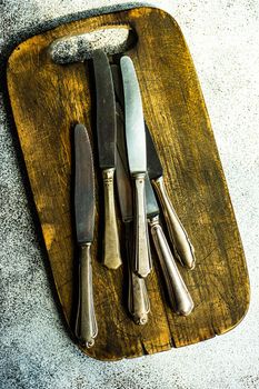 Vintage cutlery on cutting board on the table